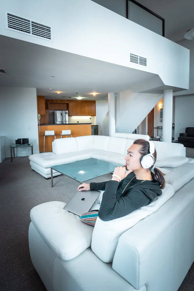 Freeman Fung inside a penthouse, sitting on the couch