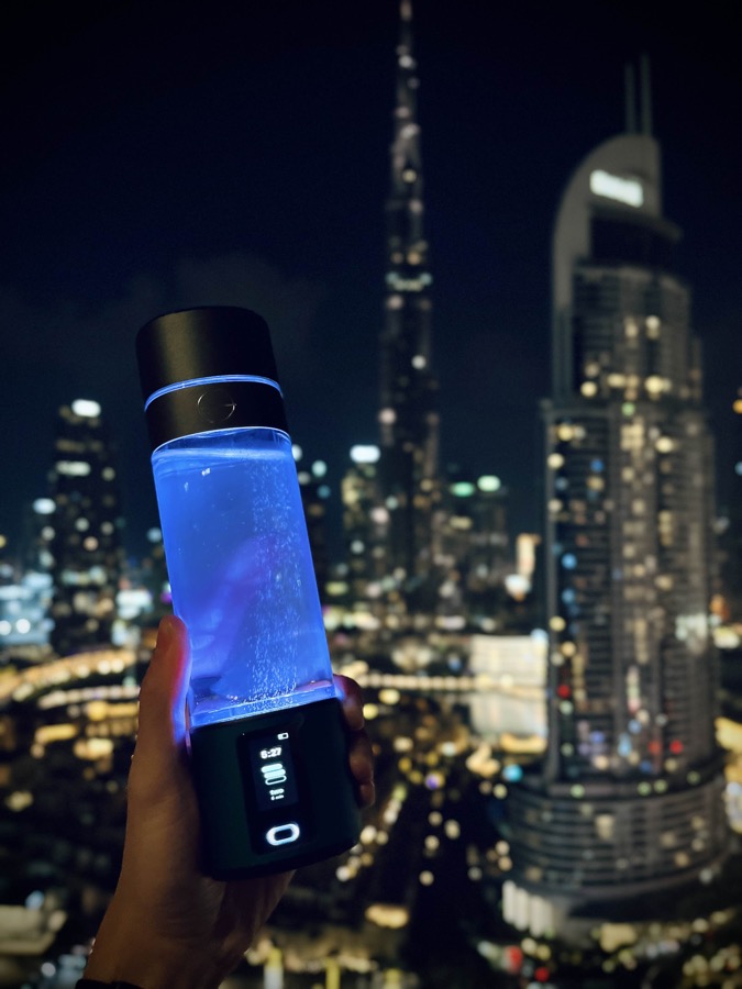 LumiVitae hydrogen bottle glowing blue against the Dubai skyline at night