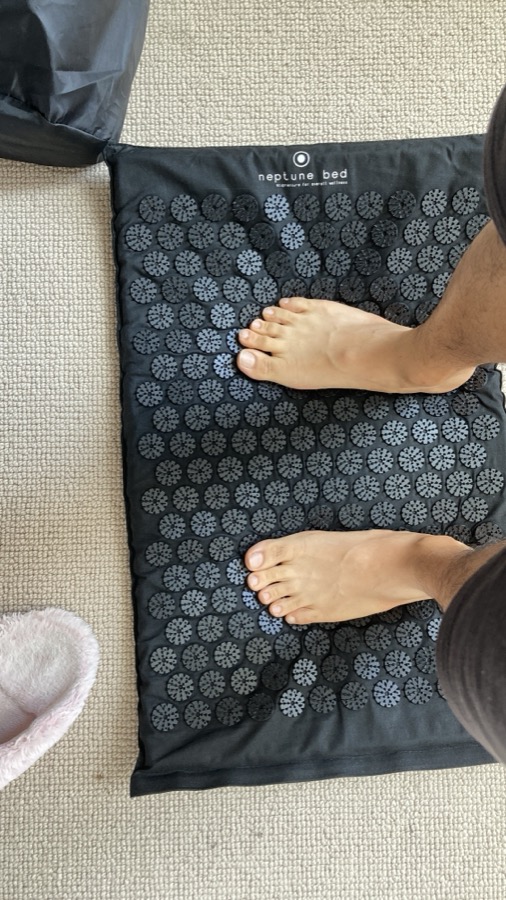 Standing barefoot on a Neptune Bed acupressure mat