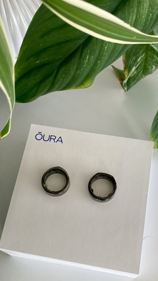 Oura Ring unboxed on its packaging next to a houseplant