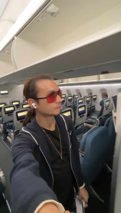Freeman Fung wearing TrueDark red-tinted glasses on a flight